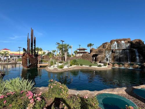 a waterfall and a pond in a theme park at Lovely 2-level 2-bedroom cottage, 1 block to beach in Myrtle Beach
