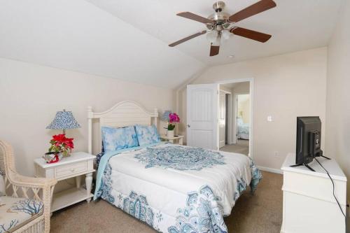 默特尔比奇Lovely 2-level 2-bedroom cottage, 1 block to beach的带床和吊扇的卧室