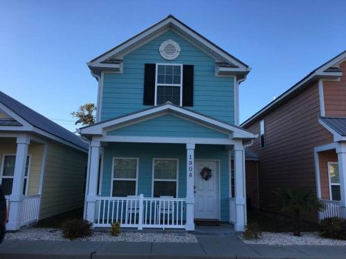 a blue house with a white front door at Lovely 2-level 2-bedroom cottage, 1 block to beach in Myrtle Beach