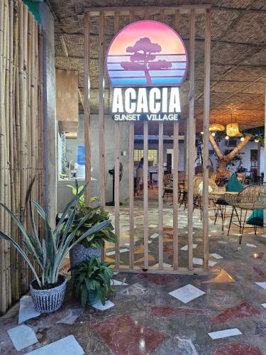 a sign for an acacia sunset village in a restaurant at Acacia Sunset Village Inn in Dauis