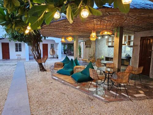 a patio with a couch and a table and chairs at Acacia Sunset Village Inn in Dauis