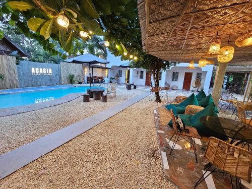 an outdoor patio with a pool and a table and chairs at Acacia Sunset Village Inn in Dauis