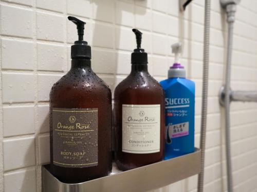 three bottles of wine on a shelf in a bathroom at Rembrandt Cabin Shinjuku Shin-Okubo in Tokyo