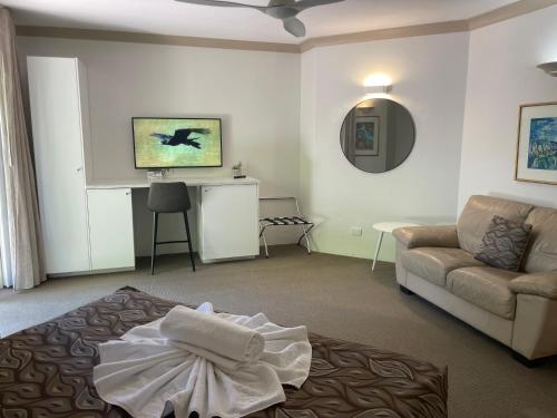 a living room with a couch and a table at Oasis Inn Ulladulla - Welcoming Guests 18 Years and Older in Ulladulla