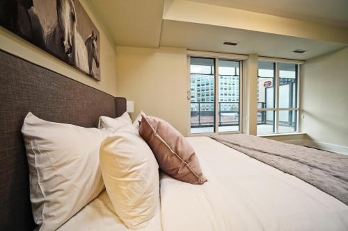 a bedroom with a bed with pillows and a window at Rivetstays - The Atmos I in Toronto