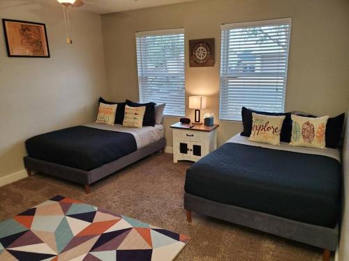 a bedroom with two beds and a table and windows at Tranquil Mesa Retreat in Mesa