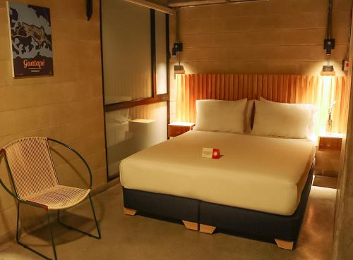 メデジンにあるCytrico Hotel Laureles Estadioのベッドと椅子のある寝室