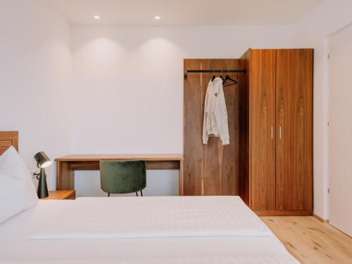 a bedroom with a bed and a wooden closet at The Hills Merano in Merano