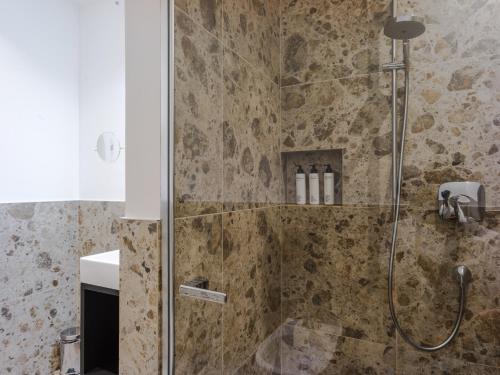 a bathroom with a shower with a glass door at The Hills Merano in Merano