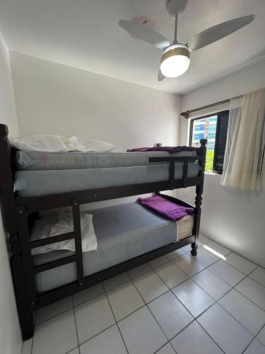 a bunk bed in a room with a ceiling at Triplex White em Caiobá-Matinhos-Pr a 200 mt do mar in Matinhos