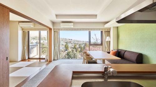 a living room with a couch and a table with a view at Tokyu Vacations Izukougen in Ito
