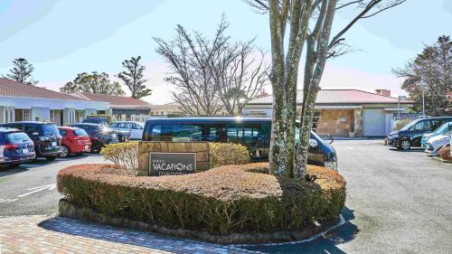 a car parked in a parking lot with a tree at Tokyu Vacations Izukougen in Ito