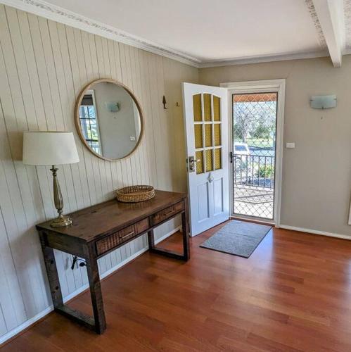 a room with a table and a mirror and a door at Cupie's Cabin in Talbingo