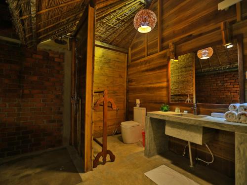 a bathroom with a sink and a toilet at Thejan Beach Cabanas in Bentota