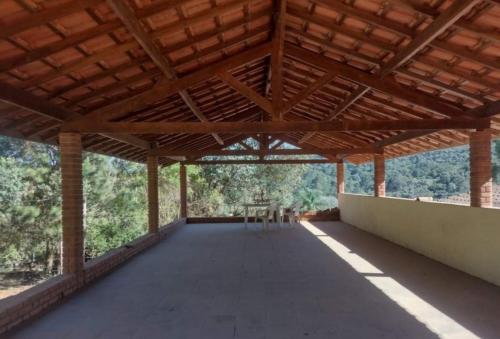a large wooden pavilion with a table and chairs at Espaço Azul in Ibiúna