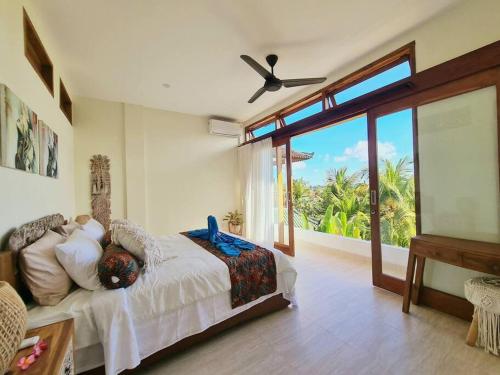 a bedroom with a bed and a large window at Exquisite luxury Villa Candidasa in Candidasa