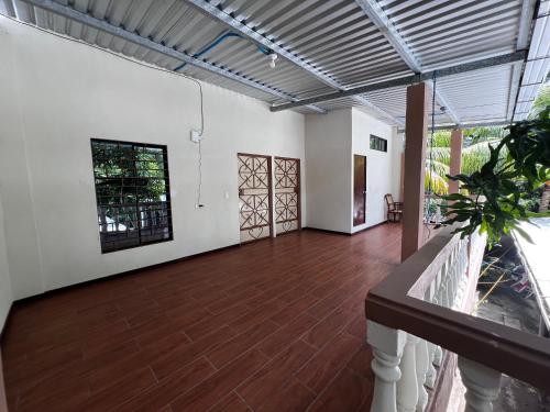 a large room with a wooden floor and white walls at Ibania Hostal in Tamanique
