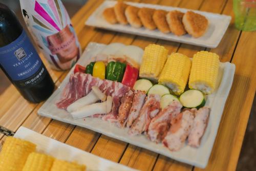 two plates with different types of food on a table at 古民家ワーケーション ふふ庵｜駅徒歩5分｜ゆる旅｜屋根在りBBQ施設｜テレワーク in Ōhara