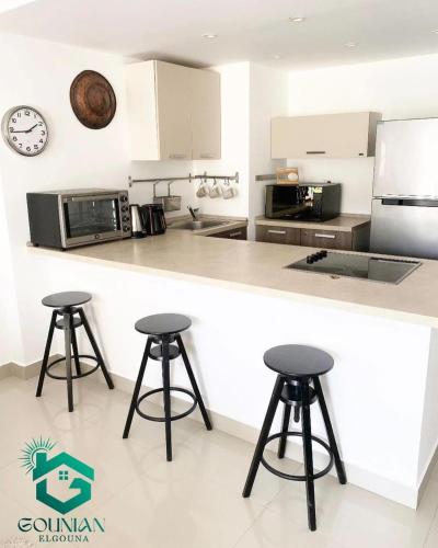 a kitchen with two bar stools and a counter at El Gouna -G-cribs B6 in El Gouna