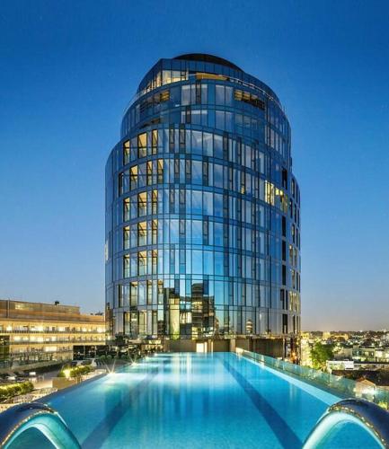 a large glass building with a pool in front of it at Parkside Perfection Near The CBD in Melbourne