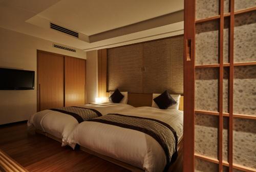 a hotel room with two beds and a television at Tokyu Vacations Kyoto in Kyoto