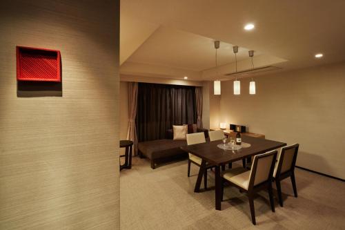 a dining room with a table and a couch at Tokyu Vacations Kyoto in Kyoto