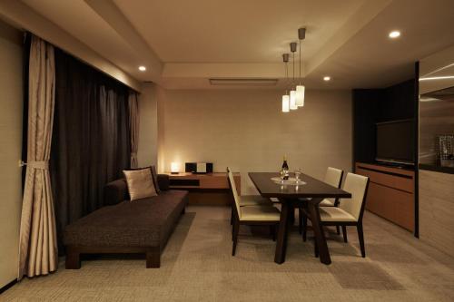 a dining room with a table and chairs and a couch at Tokyu Vacations Kyoto in Kyoto