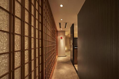 a hallway with a wall of wood panels at Tokyu Vacations Kyoto in Kyoto