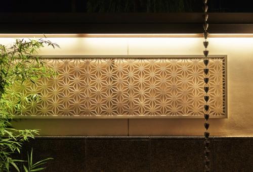 a wall with a screen with a geometric pattern at Tokyu Vacations Kyoto in Kyoto