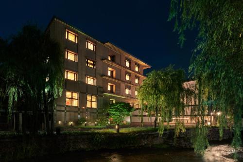 a building next to a river at night at Tokyu Vacations Kyoto in Kyoto