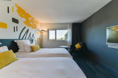 Postel nebo postele na pokoji v ubytování Golden Tulip Roissy Saint Witz