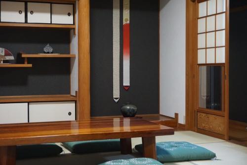 a dining room with a table and a shelf at 徳治郎の宿 in Izumi-Sano
