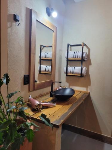 a bathroom with a sink with a mirror and towels at Pousada Chácara Kioski in Brotas