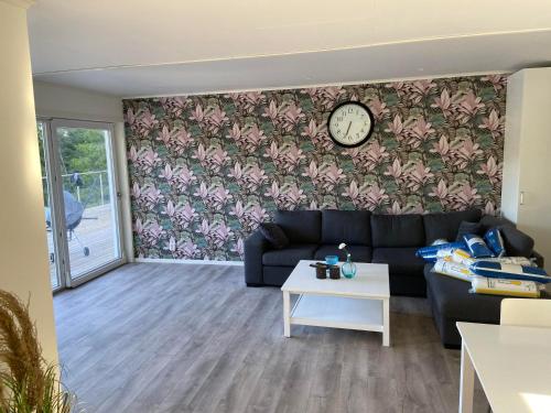 a living room with a couch and a clock on a wall at Awesome Home In Vena With 1 Bedrooms And Jacuzzi in Vena