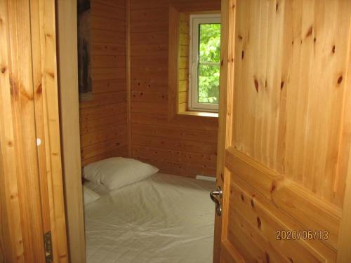 a room with a bed in a wooden room with a window at Stunning Home In Mellerud With 3 Bedrooms in Mellerud