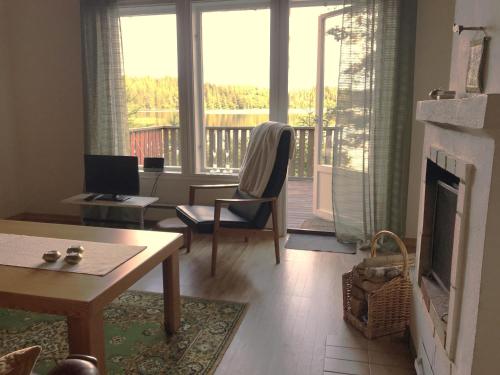 a living room with a fireplace and a view of a deck at Awesome Home In Åsenhöga With 2 Bedrooms in Åsenhöga