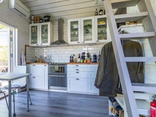 a kitchen with white cabinets and a ladder at Awesome Home In Drottningsskär With 0 Bedrooms in Drottningskär