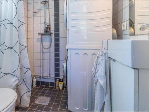 a bathroom with a white refrigerator and a toilet at Awesome Home In Drottningsskär With 0 Bedrooms in Drottningskär