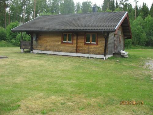a small wooden cabin with a grass yard at Awesome Home In Mellerud With 3 Bedrooms And Sauna in Mellerud