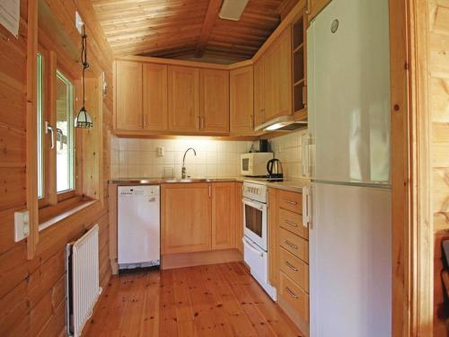 a kitchen with wooden cabinets and white appliances at Awesome Home In Mellerud With 3 Bedrooms And Sauna in Mellerud