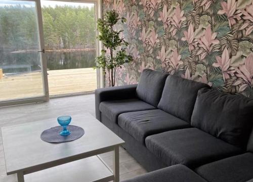 a living room with a black couch and a table at Awesome Home In Vena With 1 Bedrooms And Jacuzzi in Vena