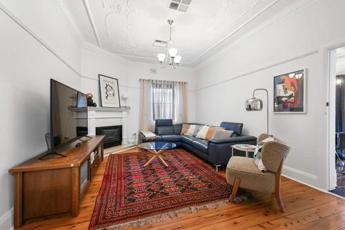 a living room with a couch and a tv at Gardiner Cottage - Stylish & Elegant, Walk to CBD in Orange