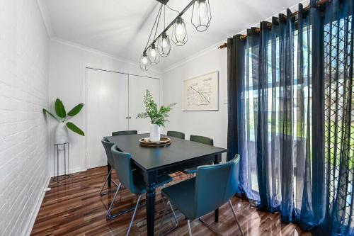 a dining room with a black table and chairs at Gardiner Cottage - Stylish & Elegant, Walk to CBD in Orange
