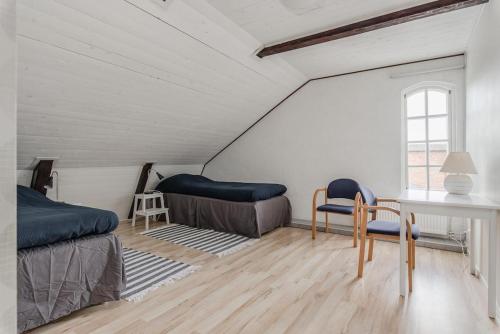 a bedroom with two beds and a table and chairs at Amazing Home In Gästrike-Hammarby With 4 Bedrooms And Wifi in Hammarby