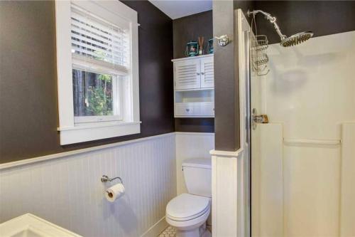 a bathroom with a toilet and a window at Seabrook 2 Bedroom cottage with hot tub, pets OK in Pacific Beach