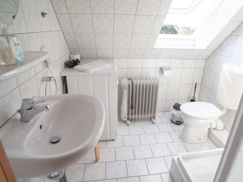 un bagno bianco con lavandino e WC di Koserow Comfortable holiday residence a Ostseebad Koserow