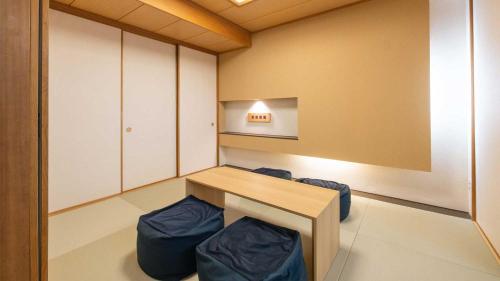a room with a wooden table and blue stools at Tokyu Vacations Hakone Gora in Hakone