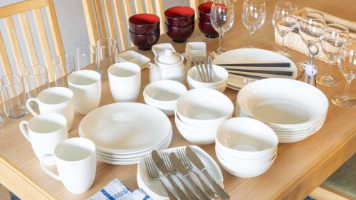 a table with white dishes and wine glasses on it at Tokyu Vacations Hakone Gora in Hakone
