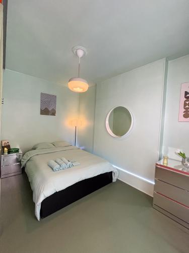 une chambre avec un lit et un miroir dans l'établissement Surperbe appartement rétro Paris, à Ivry-sur-Seine