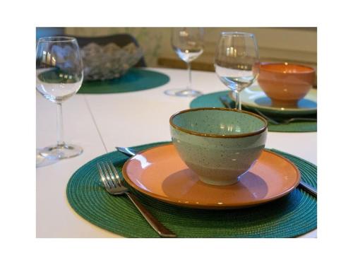 a bowl on a plate on a table with wine glasses at Holiday apartment Möwenblick in Norden